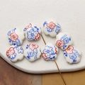 Macro shot of hand-painted floral ceramic beads with white background and red accents - Blue Orange (12#)