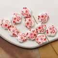 Macro shot of white ceramic plum blossom beads with red floral patterns for DIY jewelry - Red (7#)