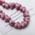 Detailed view of glossy mauve ceramic heart beads for DIY jewelry and earring making - Light Purple