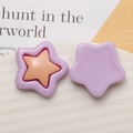 Detailed view of purple resin star-shaped charms for DIY jewelry and accessories on a tray - Purple + Light Pink