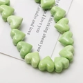 Macro view of light green glossy heart ceramic beads for DIY jewelry making accessories - Green