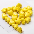 Polished yellow ceramic heart-shaped beads arranged in a heart pattern for DIY jewelry - Yellow