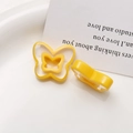 Close-up of yellow resin butterfly charms with hollow design on white tray - Yellow Butterfly