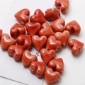 Macro shot of orange-red heart ceramic beads with glazed texture for DIY jewelry making - Light Coffee