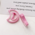 Macro view of two pink resin crescent moon charms with hollow design for jewelry making - Pink Crescent Moon