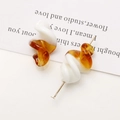 Detail view of two-tone spiral resin earrings in amber and white with gold pins - 1 Piece / Coffee