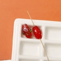 Macro detail of oval red glass bead with hand-painted gold leaf roses and green leaf pattern - 1 Piece (17x12mm) / Red