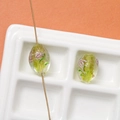 Macro shot of oval green lampwork beads with gold foil and pink floral details for DIY - 1 Piece (17x12mm) / Light Yellow