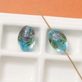Macro detail of oval blue glass beads with gold leaf and green floral inner texture - 1 Piece (17x12mm) / Light Blue