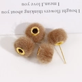 Dettaglio macro di sfere di peluche marroni con grandi occhielli in metallo dorato per fai-da-te - Marrone