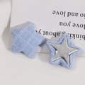 Detalle macro de botones de tela estrella azul con incrustación de estrella de metal plata - Azul claro