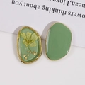 Detail view of oval resin earrings with dried flowers and green finish in gold frames - Green Yellow Floral