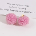Close-up of pink fluffy pom-pom charms with golden jump rings for DIY jewelry making - Fluffy Pink