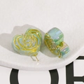 Macro-opname van hartvormige groene harskralen met gouden roospatroon voor DIY-sieraden - Recht Gat Hart Roos Accessoire / Lichtgroen