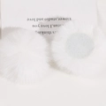 Detailed view of 50mm soft faux rabbit fur pom poms showing fluffy texture and flat back - White