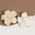 Macro detail of flocked flower charms with pearl centers for DIY hair accessories - Off White