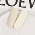 Détail de deux barrettes ovales en résine floquée beige clair sur une assiette blanche - Blanc