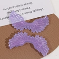 Macro detail of purple glittery angel wing acrylic charms for DIY jewelry making accessories - Deep purple