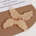Macro detail of gradient pink glitter angel wings acrylic DIY jewelry accessories - Orange