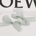 Detailed view of light green organza handmade bow hair clips on a stone tray - Light Green