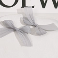 Detail of grey mesh bow hair clips with metallic luster on white ceramic tray - Gray