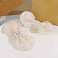 Dettaglio di un fermaglio a fiocco in acetato iridato con strass e finitura madreperla - Bianco Perlato