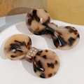 Detail of tortoise shell bow hair clips with rhinestones on a white ceramic tray - Light Coffee