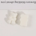 Detailed macro of white flocked teddy bear charms for DIY jewelry and accessories - White