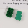 Macro view of green teddy bear resin charms with flocked and smooth surface texture - Green