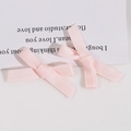 Détail macro de deux nœuds en ruban rose clair faits main pour accessoires cheveux DIY - Rose