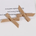 Gros plan de pinces à cheveux faites à la main avec nœud en ruban gros-grain doré - Café Clair