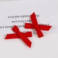 Gros plan de deux nœuds en ruban rouge faits main pour pinces à cheveux et accessoires DIY - Rouge