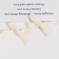 Détail de nœuds en tissu blanc crème montrant la texture tissée pour accessoires de cheveux DIY - Blanc Cassé