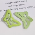 Detailansicht grüner Schmetterlings-Haarspangen mit glänzender Metalloberfläche - Grün