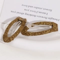 Macro-opname van druppelvormige haarspeldjes met bruin en goud metallic vlechtwerk - Donker Koffie