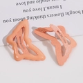 Dettaglio di fermagli per capelli a farfalla arancione corallo lucidi e opachi su bianco - Arancione