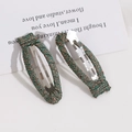 Detail of woven fabric wrapped metal oval hair clips in green and bronze tones - Peacock Green