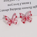 Makro-Detail von halbtransparenten rosa Harz-Schmetterlingsanhängern mit Doppellöchern für DIY - Rosa Schmetterling (Perforiert)