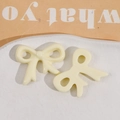 Detail of cream-colored glossy resin bow patches for DIY hair accessories and jewelry - Bow / White