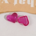Macro-opname van twee hartvormige harsbedels in magenta voor DIY-sieraden en haartoebehoren - Rozerood