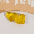 Macro-detail van een felgeel doorschijnend hars hartvormig sieraad DIY-accessoire - Geel