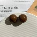 Deep brown resin half-sphere charm button with a high-gloss finish on a ceramic tray - Round / Brown