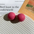 Glossy rose pink resin sphere stud earring pieces displayed on a textured ceramic plate - Round / Pink