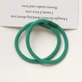 Detail of two forest green high-elastic hair ties with spiral texture and smooth connectors - Dark Green