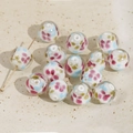 Detailaufnahme einer 14mm Glasperle mit Blumenmuster und Goldstift im Mittelloch - Runde Blumenperle / 14mm