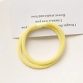 Detailed macro view of two lemon yellow elastic hair ties with fine ribbed texture - Yellow