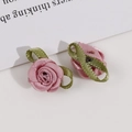 Macro detail of handmade pink satin rosebuds with green fabric leaves for DIY crafts - Pink Purple
