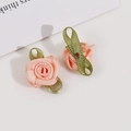 Detailed view of handmade pink polyester ribbon rosebuds with delicate green leaf accents - Champagne Pink