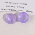 Detalle macro del cabujón acrílico morado con purpurina para bisutería artesanal DIY - Morado