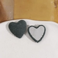 Dettaglio di toppe a forma di cuore in tessuto a coste grigio scuro con base metallica - verde scuro